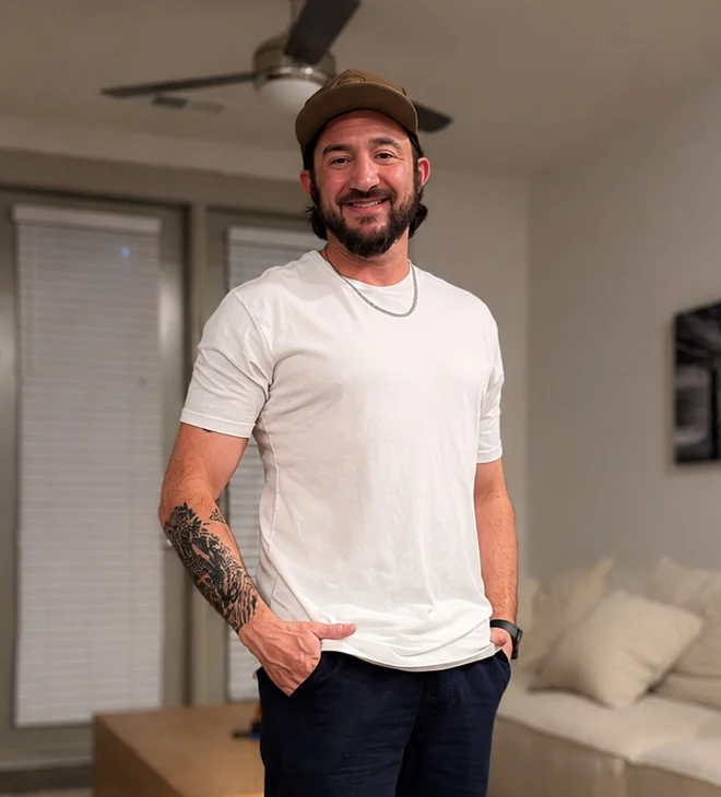 Matt, the grower behind SporeDesk, smiling in a brown cap and a white t-shirt.